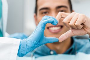 Dentist and patient creating a heart with their hands